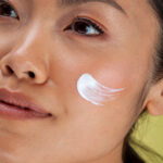 Home close up of woman with face cream on cheek